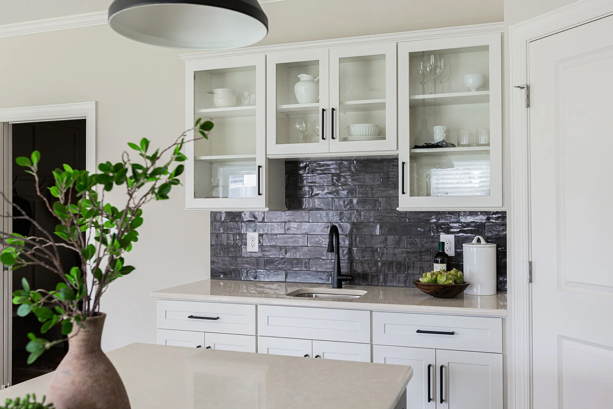 Textured black tiled backsplash with white cabinets » Martins Flooring